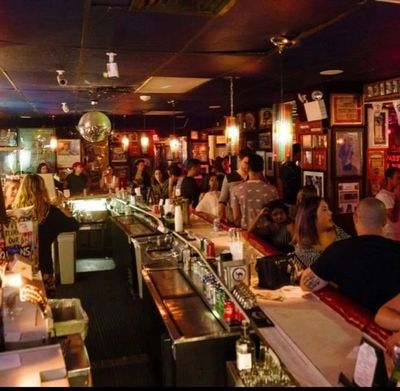 A lively bar filled with people socializing and enjoying drinks.
