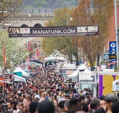 Crowded street market in Manayunk with many people and vendor tents.