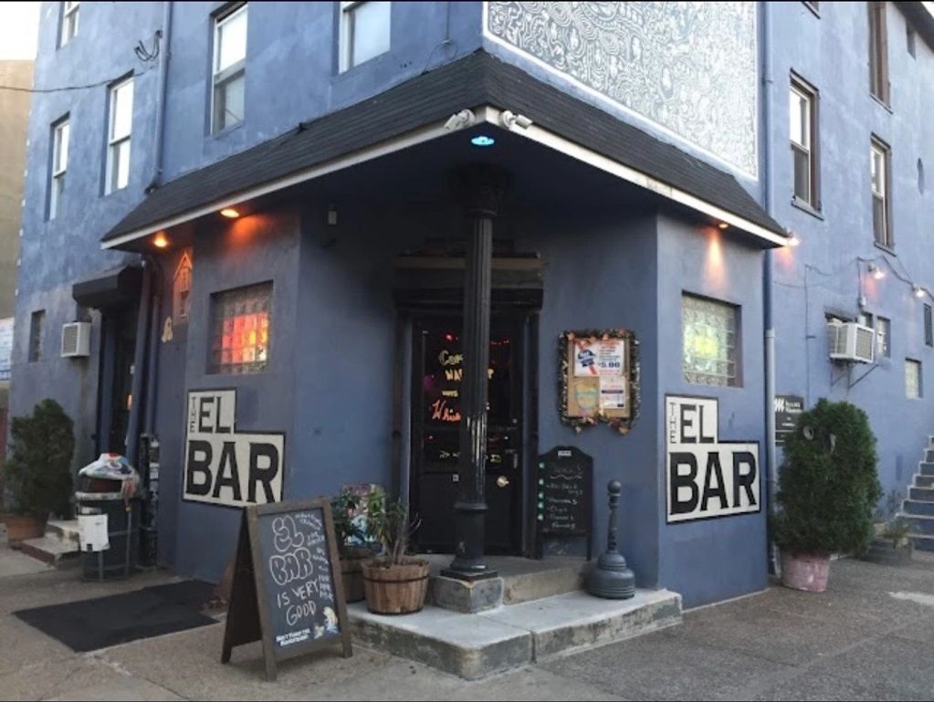 Corner bar with blue exterior and signs reading 'EL BAR'.