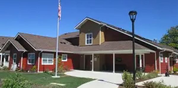 A red building with a beige roof under a clear blue sky.