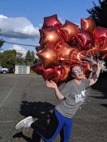 A woman holding red star balloons