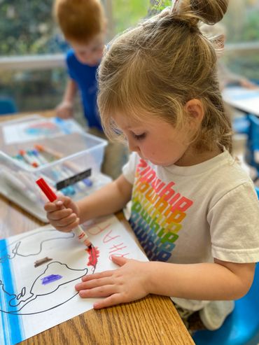 A girl using a marker to color