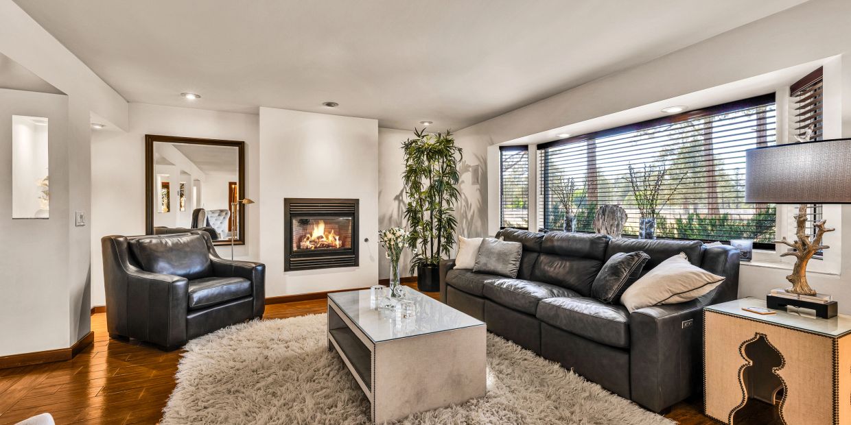 Modern living room with leather furniture and fireplace.