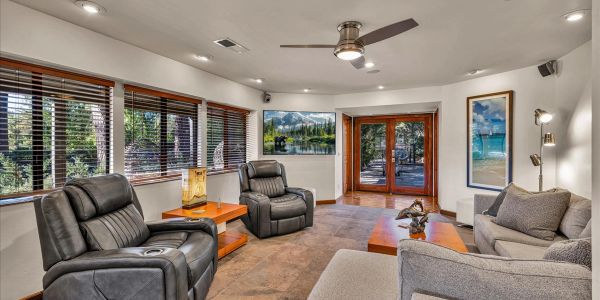 Modern living room with leather recliners and large windows.