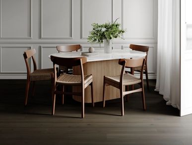 Modern dining table with four wooden chairs and a flower arrangement.