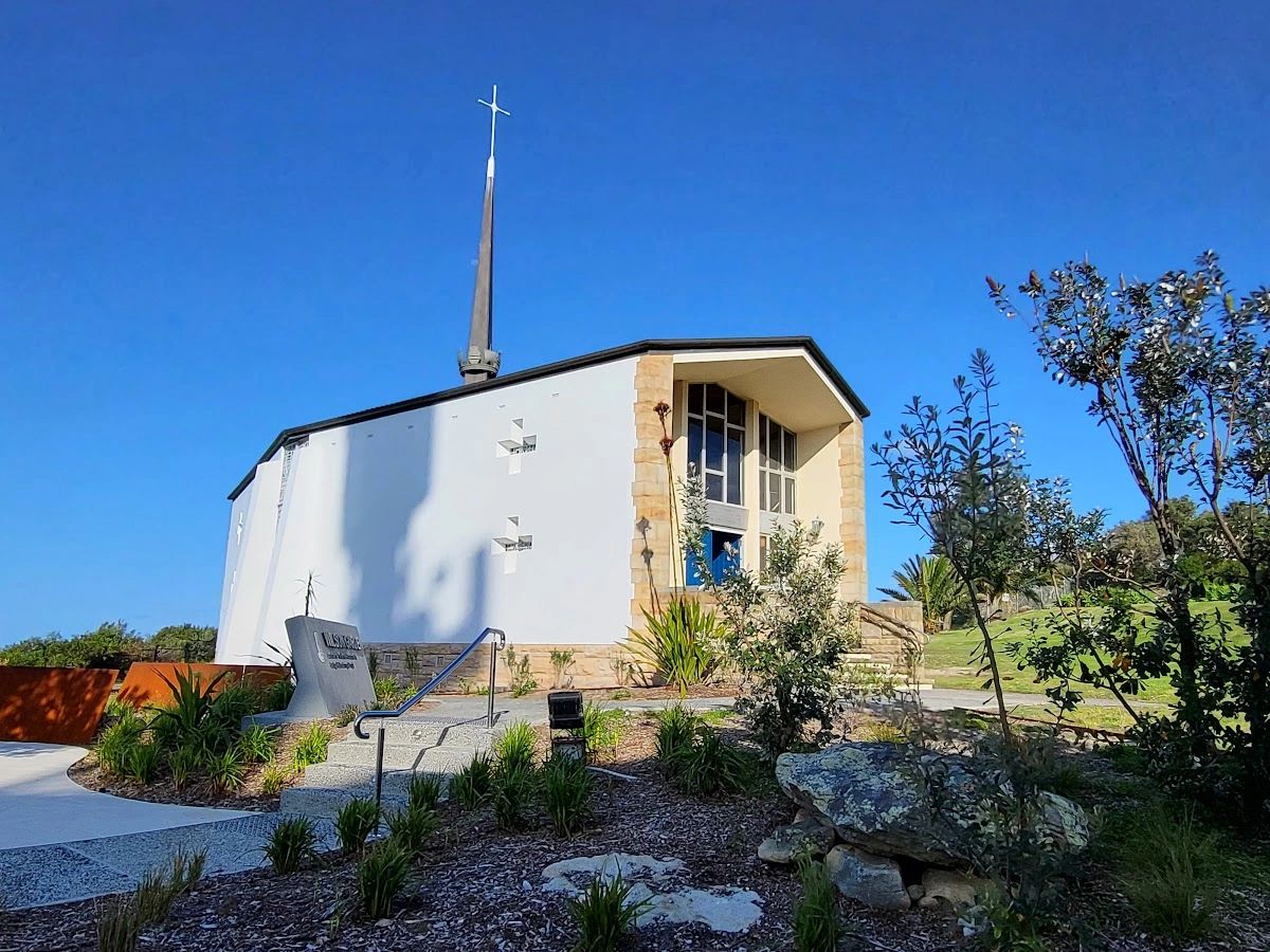 Modern church building with a tall cross steeple.