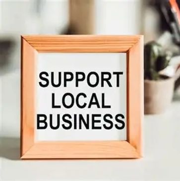 Framed sign reading 'Support Local Business' on a table.