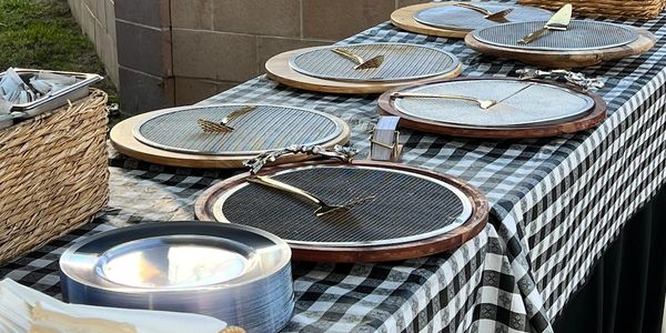 Empty serving trays on a checkered tablecloth.