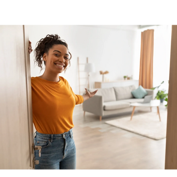 Smiling woman welcomes you into a bright, cozy living room.