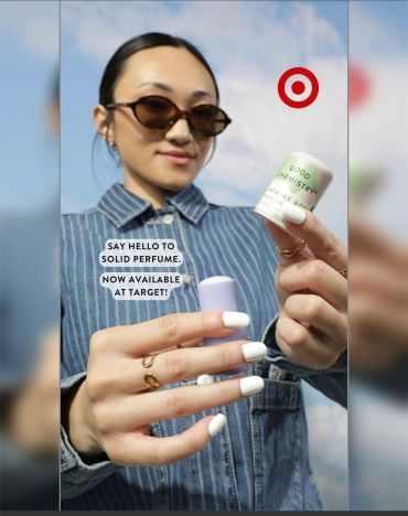 Woman holding solid perfume available at Target.