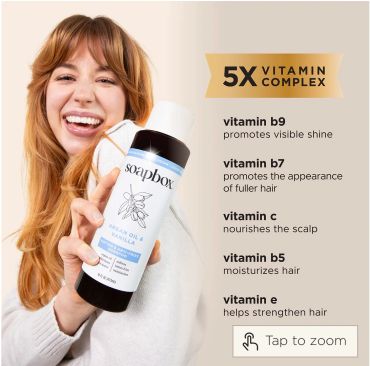 Woman holding Soapbox shampoo highlighting 5X vitamin complex benefits.