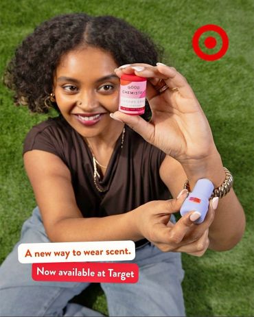 Woman holding Good Chemistry scent products with Target logo.
