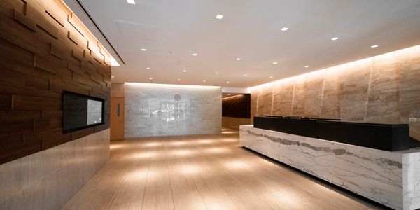Modern lobby with marble reception desk and wood-paneled walls.