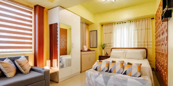 Bright, cozy bedroom with yellow walls and modern decor.