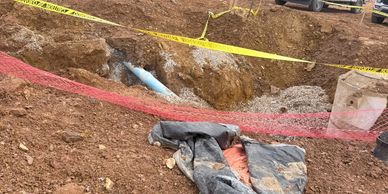 A construction site with dug trenches and protective barriers.