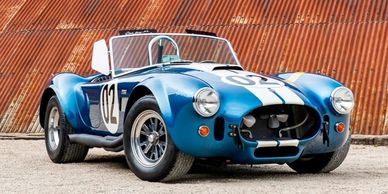 Classic blue Shelby Cobra race car with white stripes and number 02.