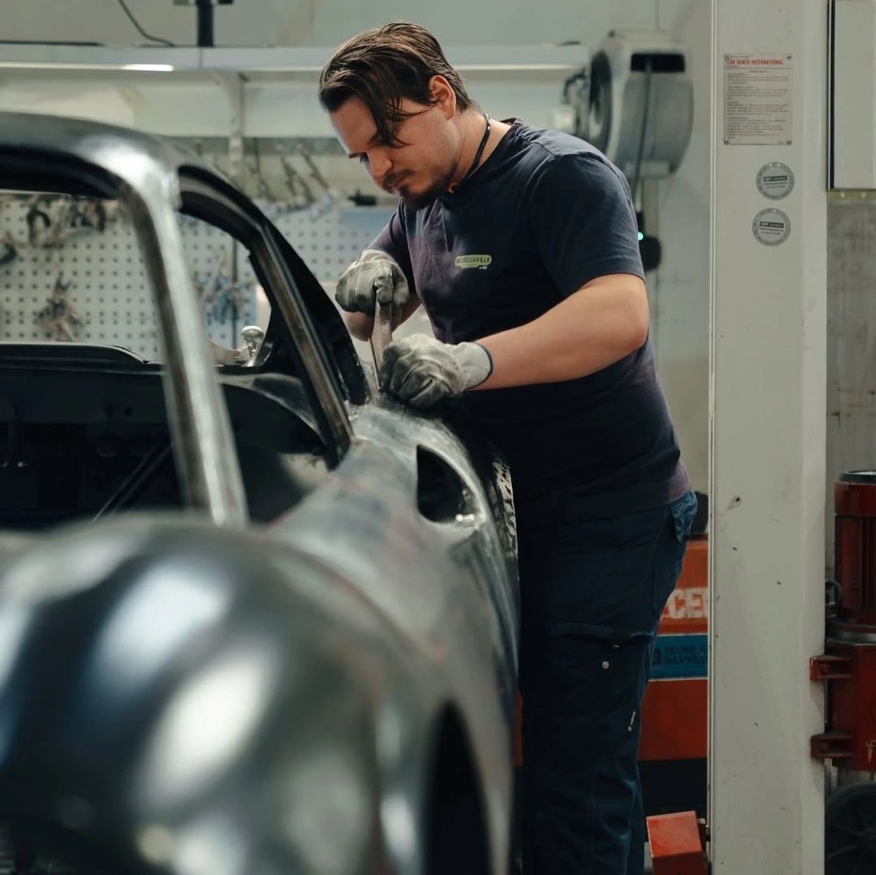 Man working on a car restoration in a garage.