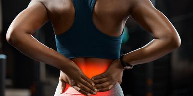 A lady holding her back because of a back injury.