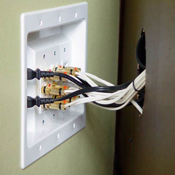 Multiple speaker wires connected to a wall plate.