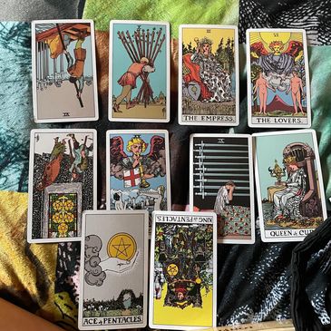 A spread of tarot cards on a colorful fabric background.