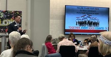 Man speaking at a community meeting about advocacy.