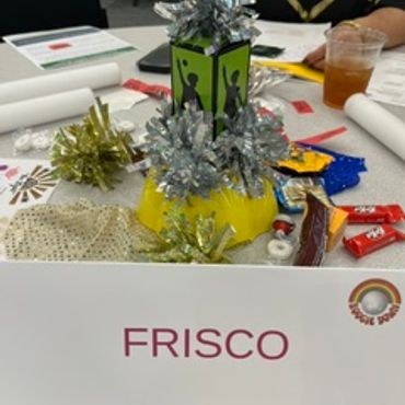 A table centerpiece and snacks with a 'FRISCO' name card.