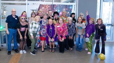 Group of people dressed up for a fun event indoors.