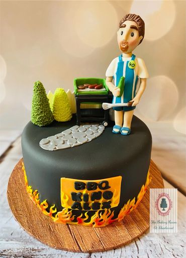 Fondant cake decorated with a fondant man and a barbecue in his garden