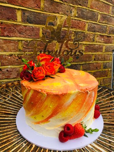 Orange yellow and cream ombré cake with roses and fruit
