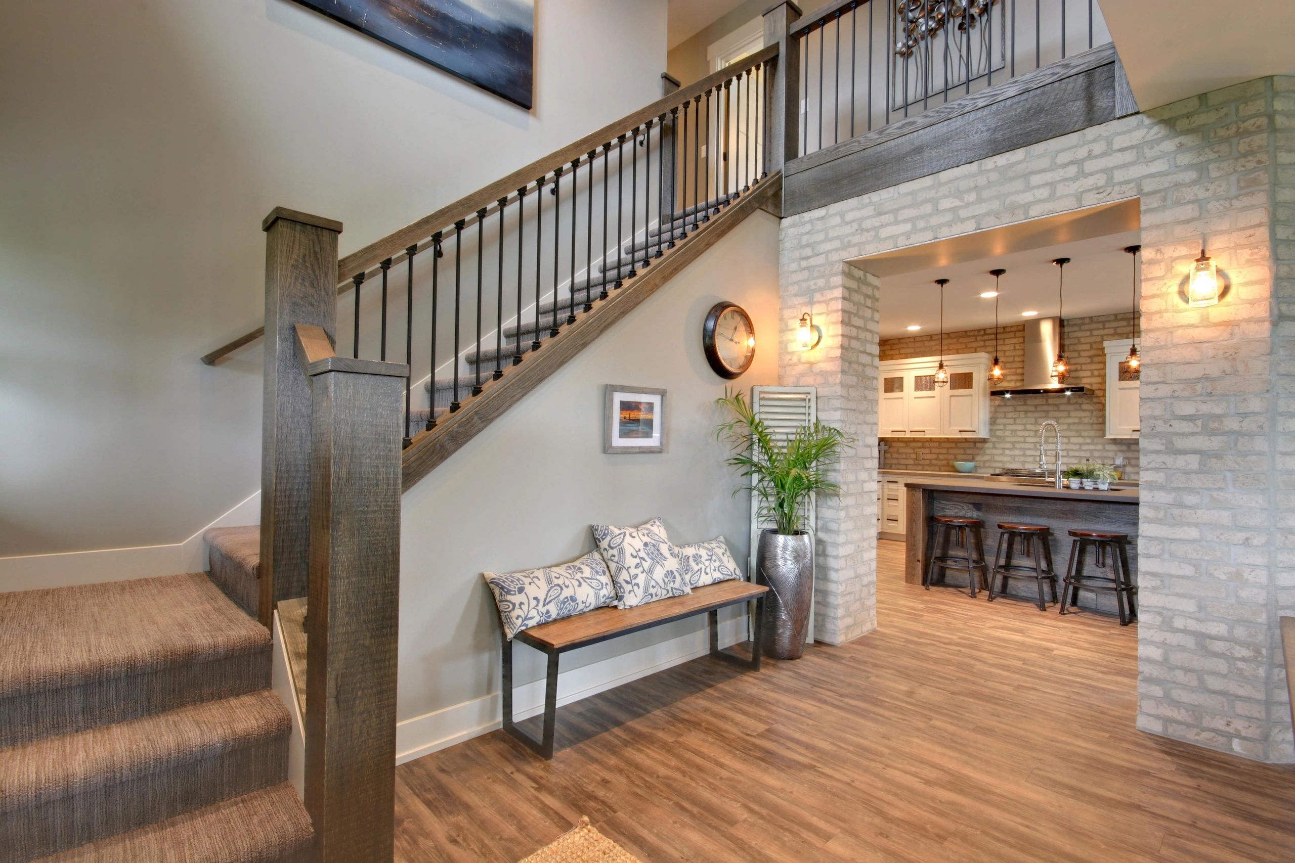 Custom entry and kitchen with whitewashed brick and wood stair detail by True North Building Group