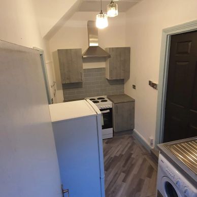 A small, narrow kitchen with modern fixtures.