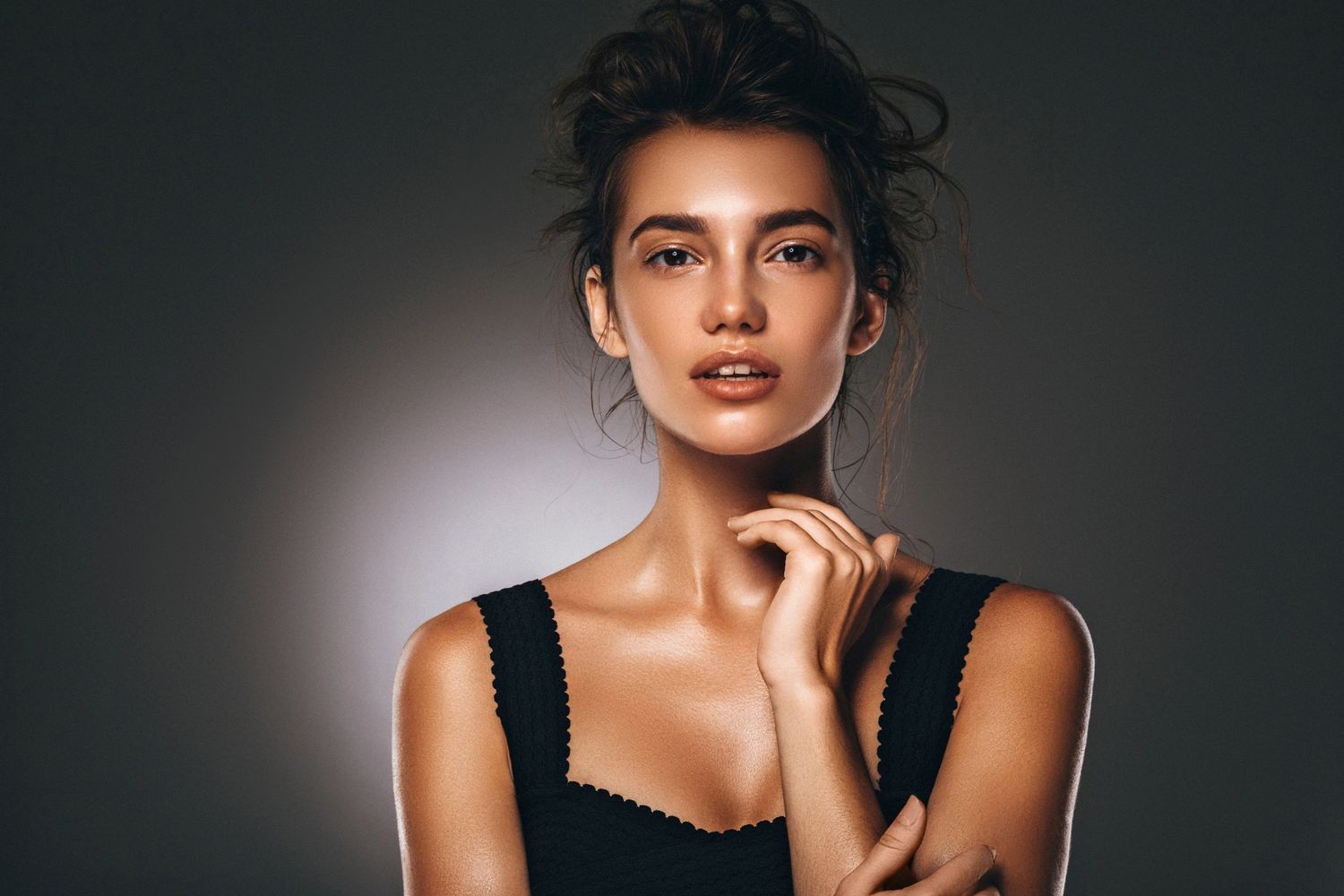 A model poses with a soft expression, showcasing natural beauty and elegant lighting.