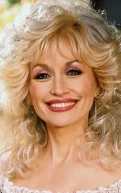 Smiling woman with curly blonde hair.
