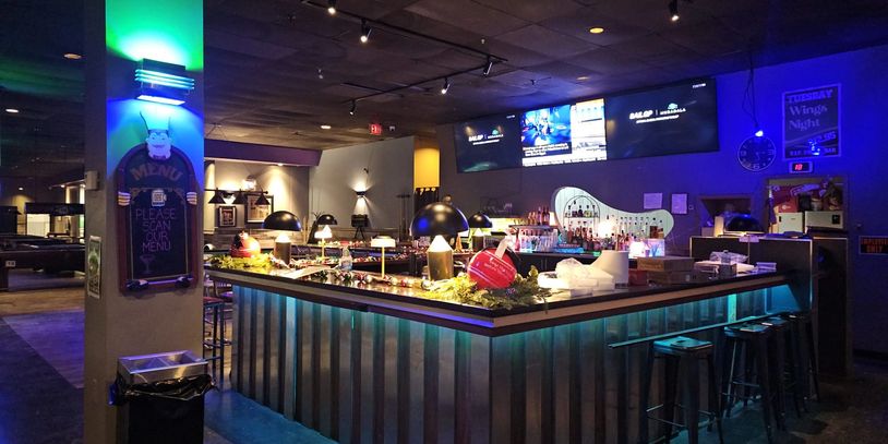 Modern bar area with festive decorations and multiple screens.