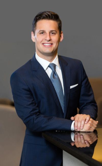 Man in a suit smiling and posing indoors.