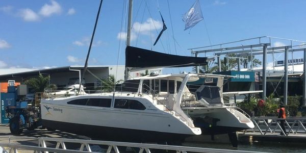 Catamaran docked in a marina on a sunny day.