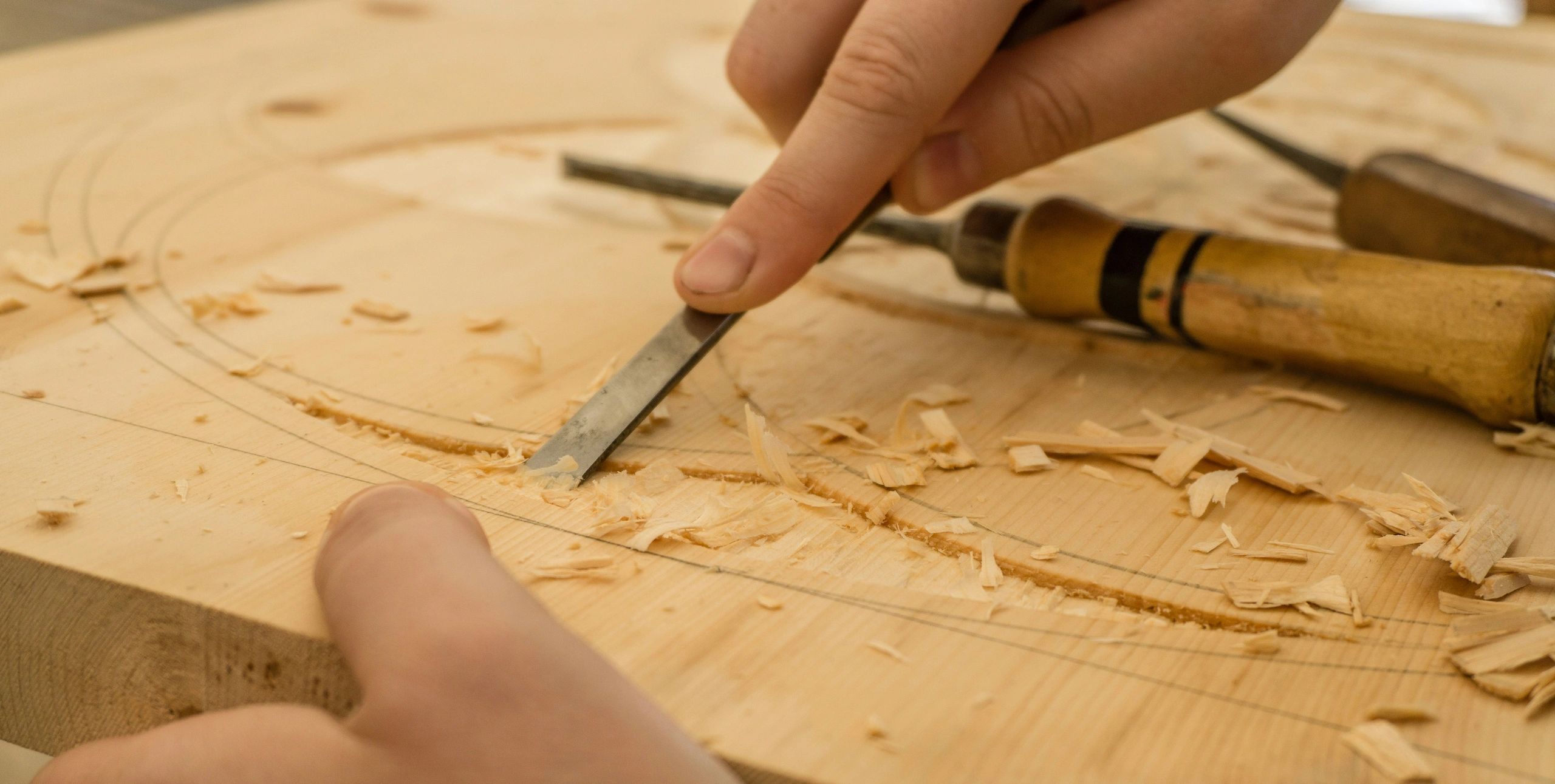 Dominik Scythe "Person using chisel while carving wood"