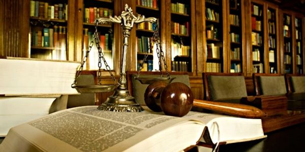 A gavel and traditional scales placed on the book 