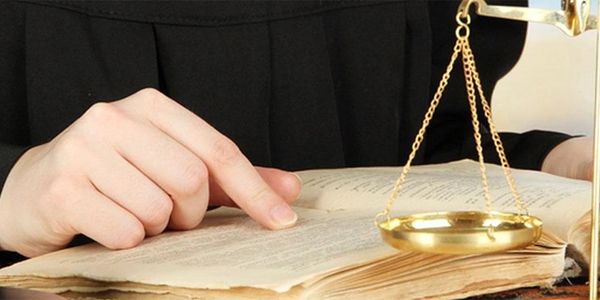 a hand holding a judge's gavel