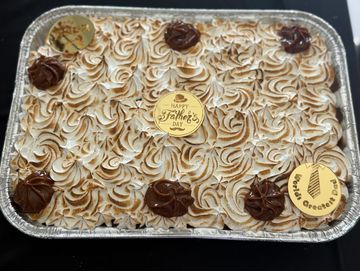 A decorated Father's Day cake with toasted meringue and chocolate swirls.