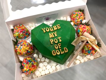 Heart-shaped green chocolate with 'You're my pot of gold' message and colorful treats.