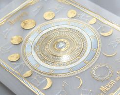 A white tarot card with gold moon cycles pictured on the card