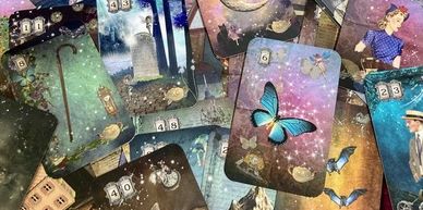 A bunch of different tarot cards that are just laid out on top of a desk