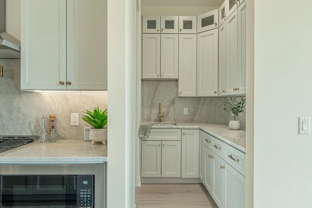 Taj Mahal Quartzite for the kitchen countertops with full height backsplash and a double vanity by D