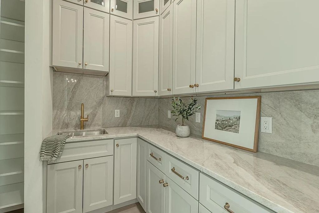 Taj Mahal Quartzite for the kitchen countertops with full height backsplash and a double vanity by D
