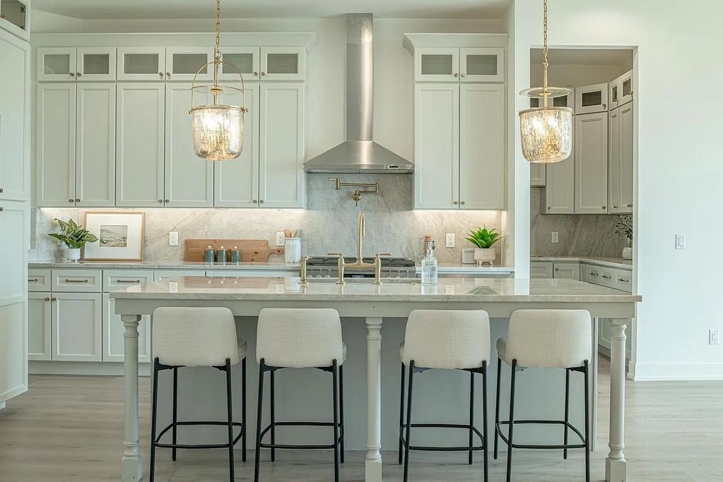 Taj Mahal Quartzite for the kitchen countertops with full height backsplash and a double vanity by D