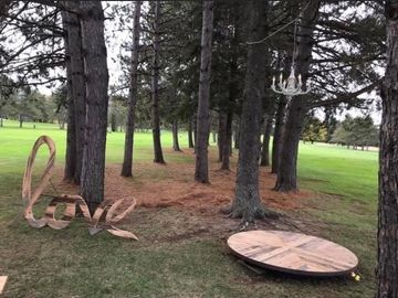 An outdoor display of wooden round stage, 6ft wooden love sign and chandelier