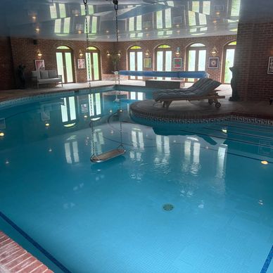 Indoor pool with seating and brick walls.