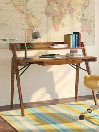 Wooden desk with books, lamp, and decorative items.