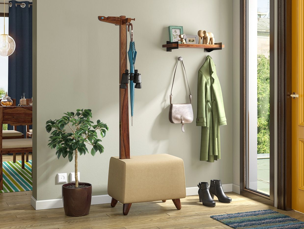 Neat entryway with coat rack, plant, and shoes.